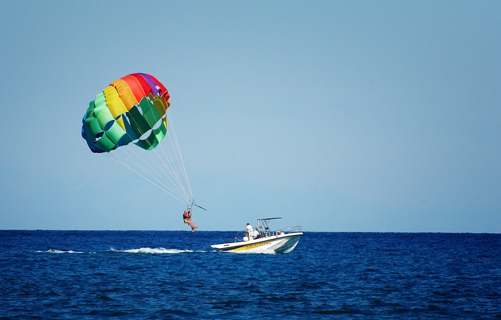 Couple parasailing after a boat - why visit Albufeira Portugal.