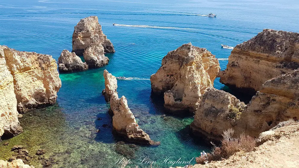 Ponta da Piedade rock formations jutting out of crystal clear water.