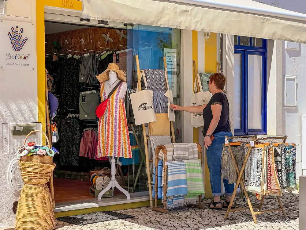 A woman is shopping for clothes in Cabanas Algarve.