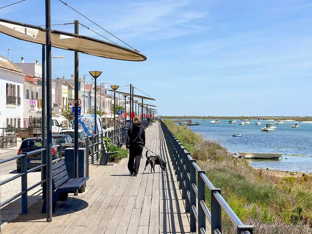 Walking along a wooden promenade which is one of the top things to do in Cabanas de Tavira Algarve.