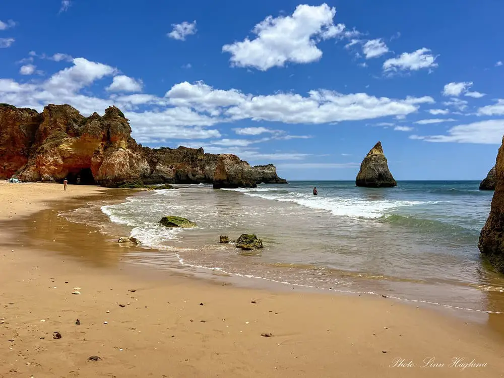 Rock formations jutting out of the water at Praia dos Tres Irmaos, one of the best Beaches in Alvor Portugal.