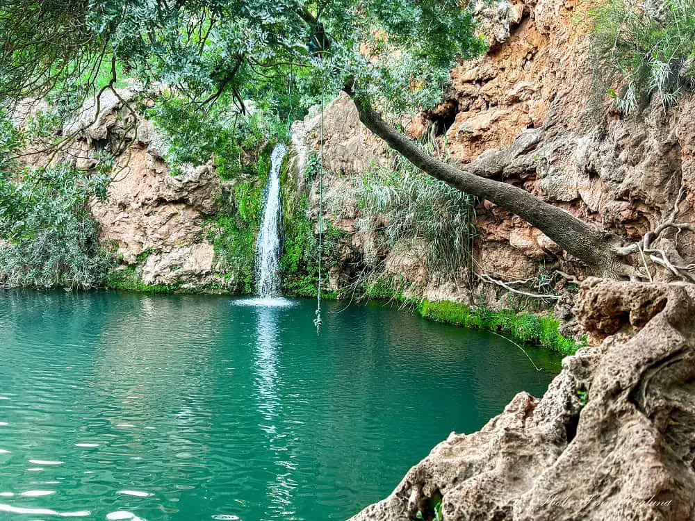 Pego do Inferno waterfall Tavira Portugal cascading into a green swimming hole.
